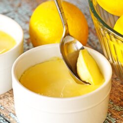 Instant Pot Lemon Custard being scooped from a white custard dish with a spoon