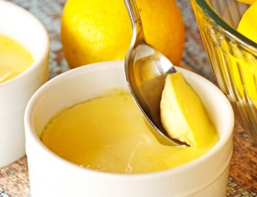 Instant Pot Lemon Custard being scooped from a white custard dish with a spoon