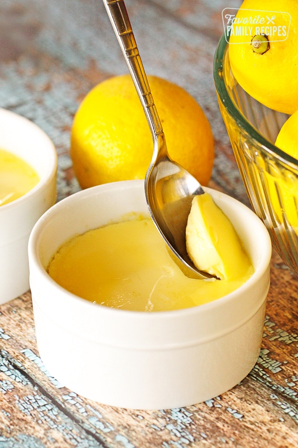 Instant Pot Lemon Custard being scooped from a white custard dish with a spoon.