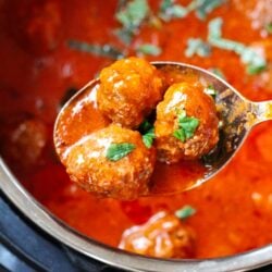Three Instant Pot Meatballs being scooped from an Instant Pot