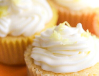 Three Lemon Buttermilk Cupcakes with white frosting and lemon zest on top