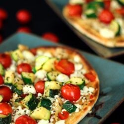 2 mediterranean flatbread pizzas on blue plates