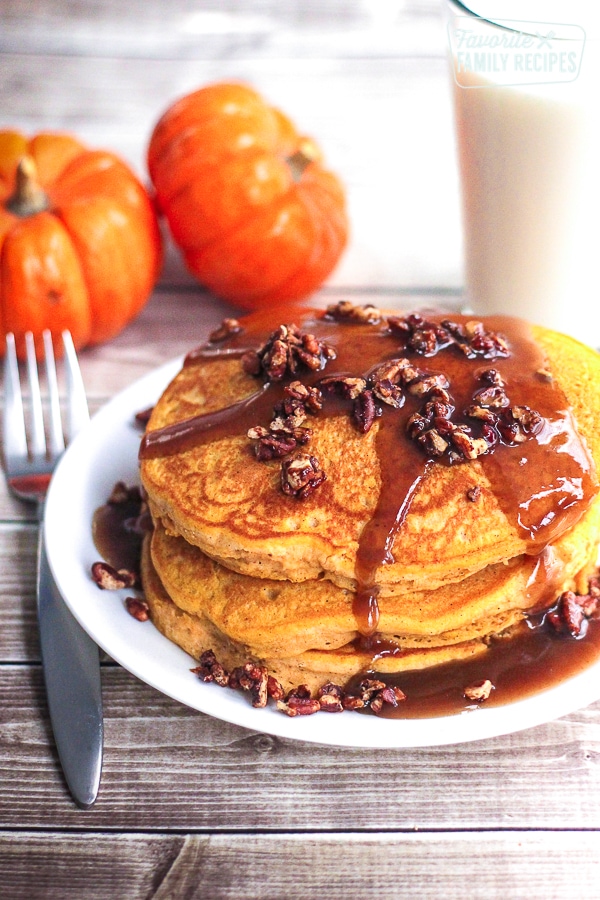 A stack of pumpkin pancakes with a pecan caramel syrup on top