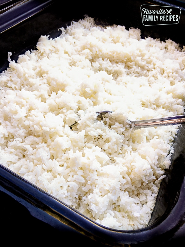 White rice in a large blue tray with a serving spoon.