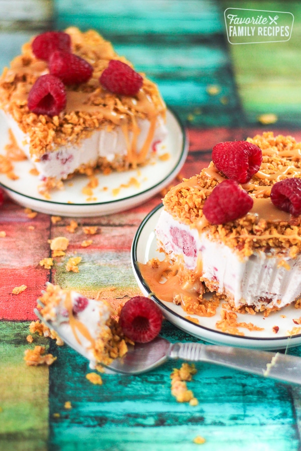 Slices of raspberry fried ice cream on two plates with a fork bite taking out of it. 