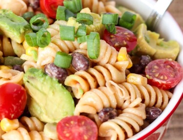 BBQ Ranch Pasta Salad in a red bowl with a silver spoon.