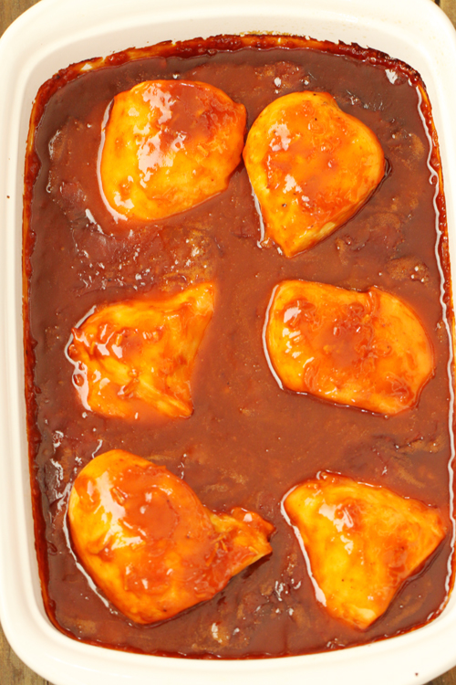 Apricot chicken in sauce in a white baking dish