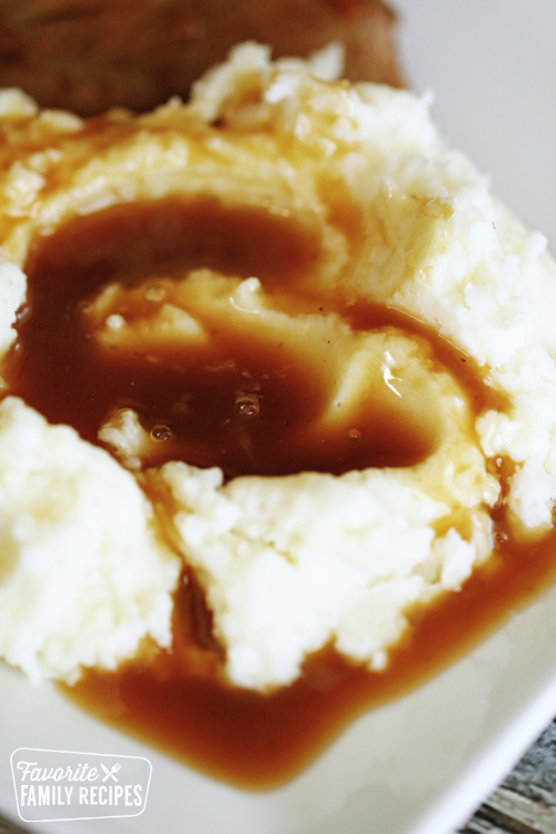 Mashed potatoes with beef gravy on a plate