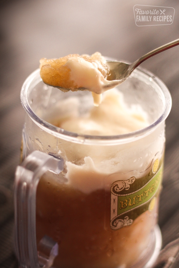 Frozen Butterbeer in a glass mug and a spoon scooping some out. 