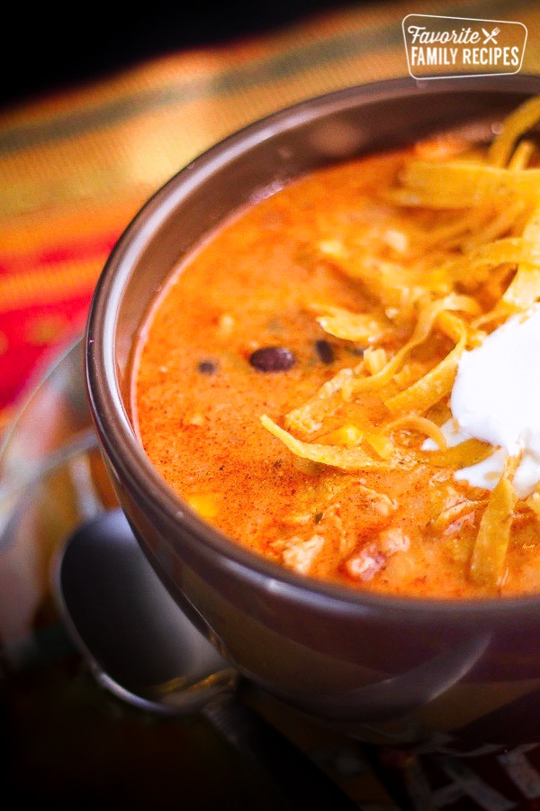 Cafe Zupas Chicken Enchilada Chili with tortilla strips and sour cream in a bowl.