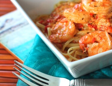 Creamy Cajun Shrimp Pasta in a white bowl with a fork on the side