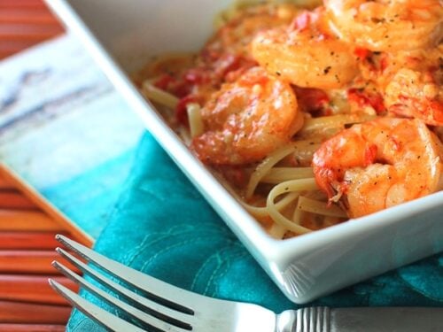 Creamy Cajun Shrimp Pasta in a white bowl with a fork on the side