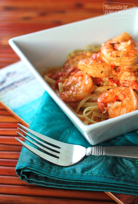 Creamy Cajun Shrimp Pasta in a white bowl with a fork on the side