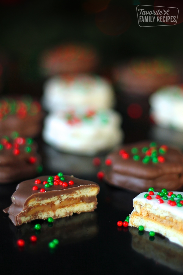 Several Dipped Ritz Cookies with Peanut Butter Filling on a black surface.