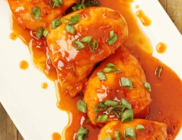 Apricot chicken in sauce on a white platter