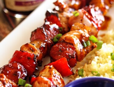 2 Grilled Honey Berry Sriracha Skewers with a side of rice on a plate.