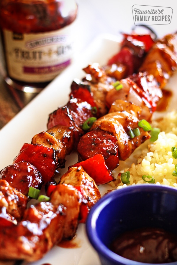 2 Grilled Honey Berry Sriracha Skewers with a side of rice on a plate.