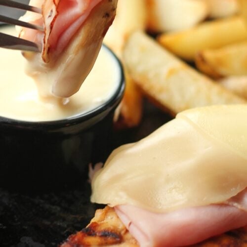 Slice of Grilled Malibu Chicken with a fork dipping a piece into a side of honey mustard.