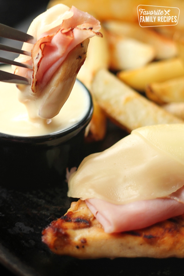 Slice of Grilled Malibu Chicken with a fork dipping a piece into a side of honey mustard.