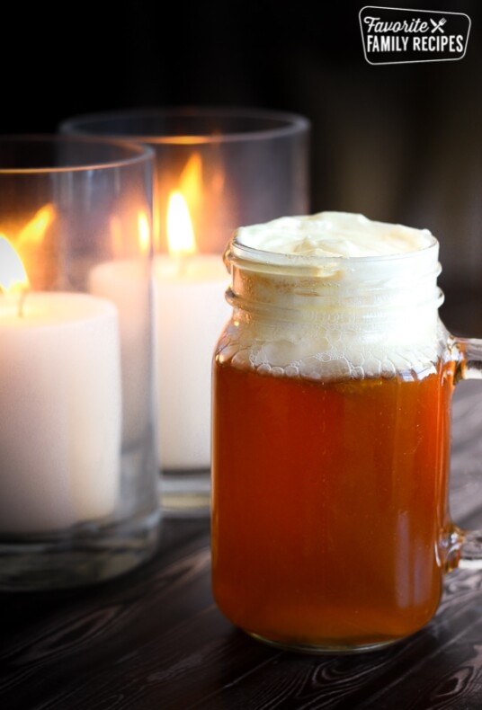 Butterbeer from the Wizarding World of Harry Potter with two candles in the background.