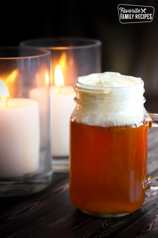Butterbeer from the Wizarding World of Harry Potter with two candles in the background.