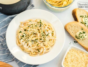 A plate of noodles topped with Homemade Alfredo Sauce and parsley flakes