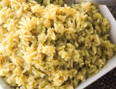 Lemon Pesto Rice in a white dish with a spoon on the side.