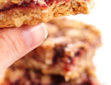 Close up of a hand holding an Oatmeal Raspberry Crumb Bar
