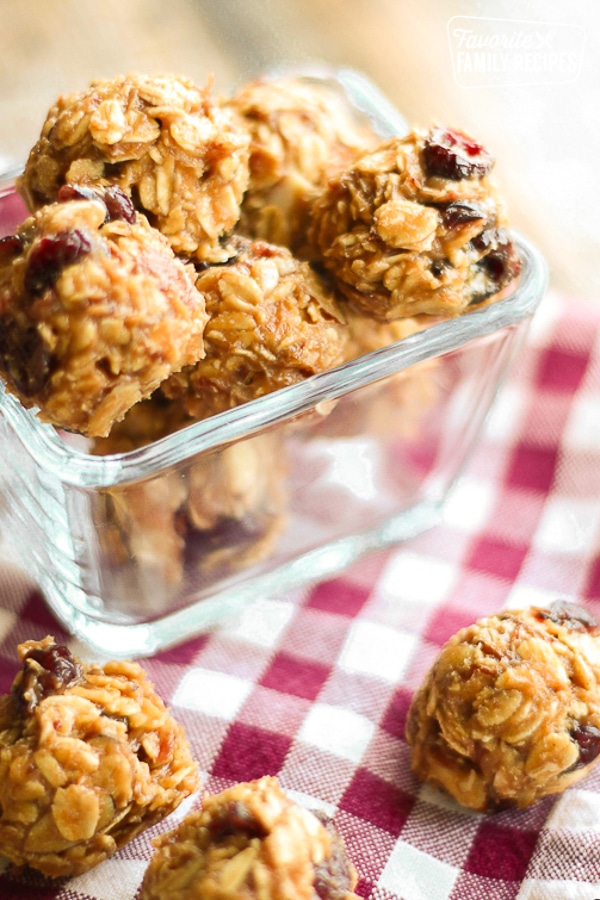 PB & J Energy Bites in a glass square bowl on a checkered table cloth.