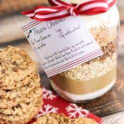 A plate of cookies with a jar of Pecan Chewies Mix in a mason jar on the side