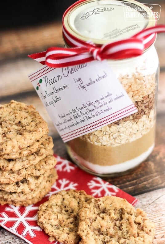 A plate of cookies with a jar of Pecan Chewies Mix in a mason jar on the side