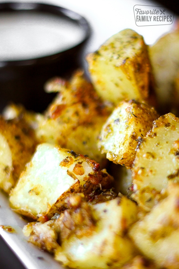 Close up of Pesto Potatoes with a side of ranch in the background.