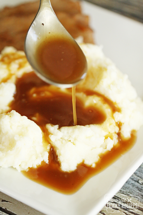 Beef gravy slowly being poured over a mound of mashed potatoes
