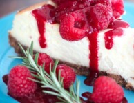 cheesecake with raspberries on a blue plate