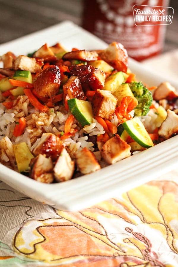 Rumbi Rice Bowl with rice, beans, grilled chicken and vegetable on a white plate