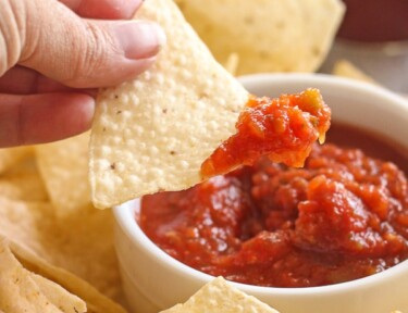 Canned Salsa in a bowl with a chip being dipped into it.