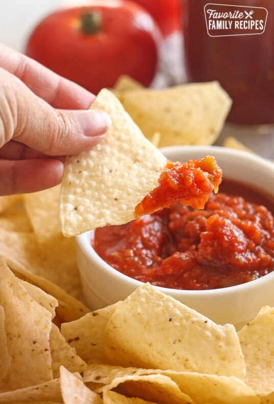 Canned Salsa in a bowl with a chip being dipped into it.