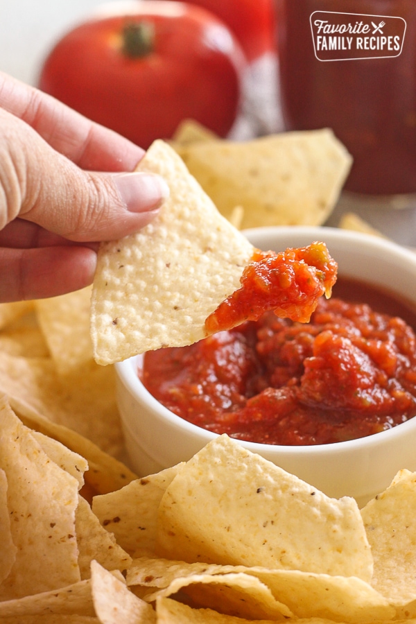 Canned Salsa in a bowl with a chip being dipped into it.