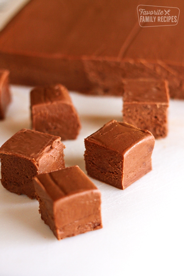 Our See's Fudge Recipe with square fudge pieces arranged in front of it