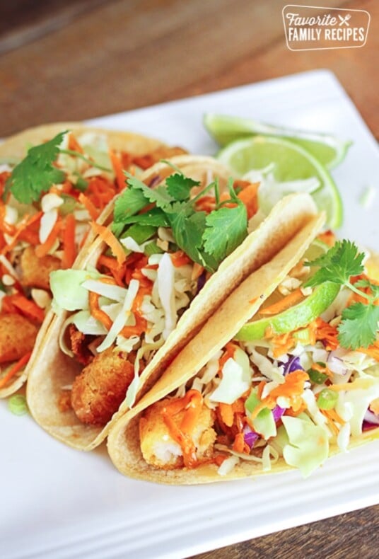 Three Thai fish tacos on a white plate.