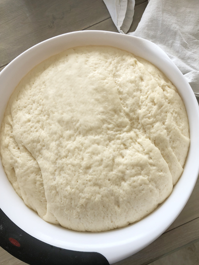 dinner roll dough in a large bowl that has risen