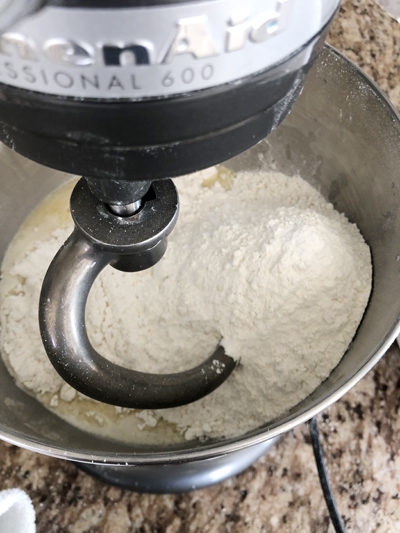 ingredients to make dinner rolls in a stand mixer ready to be mixed