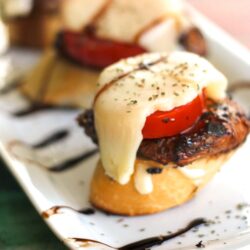 Caprese Chicken Sliders on a Sourdough Baguette on a white tray.