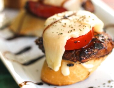 Caprese Chicken Sliders on a Sourdough Baguette on a white tray.