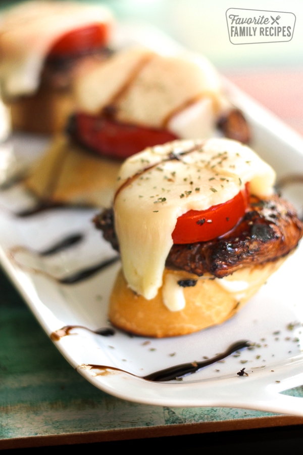 Caprese Chicken Sliders on a Sourdough Baguette on a white tray.