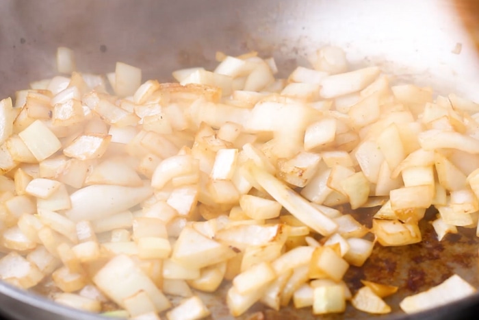 Chopped onions in a skillet for Thick and Beefy Danish Goulash.