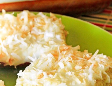 A close up of a piece of Coconut Lime Cheesecake Bars on a green plate.