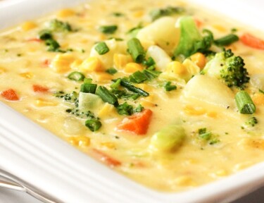 Country Vegetable Chowder in a white bowl with a spoon on the side.
