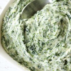 Creamed spinach in a bowl with a spoon