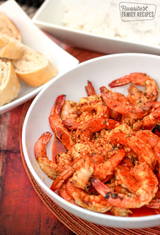 Creole Butter Shrimp in a white bowl with bread on the side.